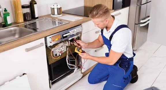 Technician testing a dishwasher with its front panel removed