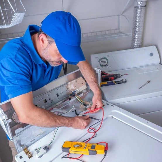 Technician testing washing machine wiring with a multimeter