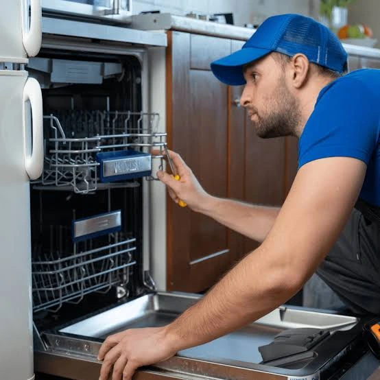 Technician examining the racks of an open dishwasher